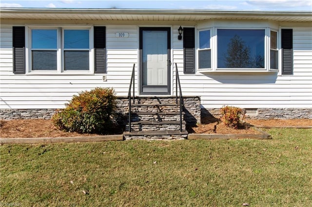 doorway to property with a yard