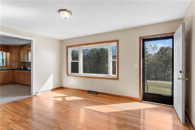 unfurnished living room with light hardwood / wood-style floors and a wealth of natural light