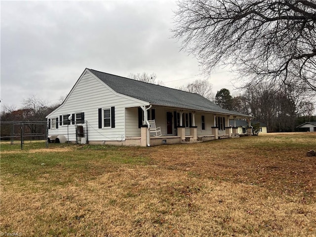 view of side of property featuring covered porch and a lawn