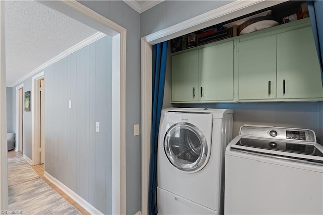 laundry room featuring cabinets, independent washer and dryer, ornamental molding, and wood walls