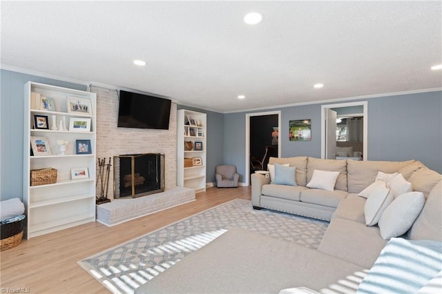 living room featuring a fireplace, light hardwood / wood-style floors, and ornamental molding