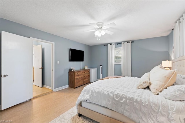 bedroom featuring a textured ceiling, light hardwood / wood-style floors, and ceiling fan