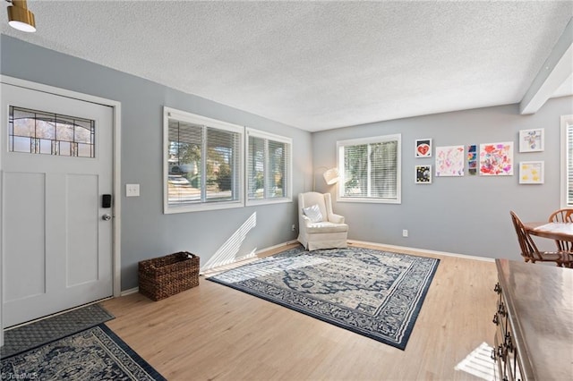 foyer entrance featuring hardwood / wood-style flooring and a textured ceiling