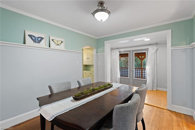 dining area with hardwood / wood-style floors and crown molding