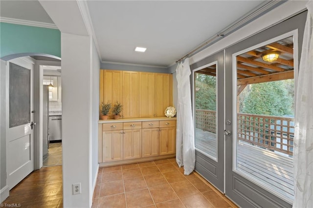 doorway to outside featuring light tile patterned floors, ornamental molding, and french doors