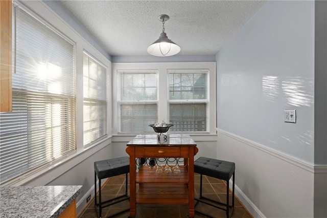 tiled dining room featuring a textured ceiling