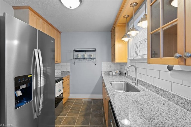 kitchen with pendant lighting, sink, light brown cabinetry, tasteful backsplash, and stainless steel appliances