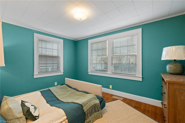 bedroom with hardwood / wood-style floors and ornamental molding