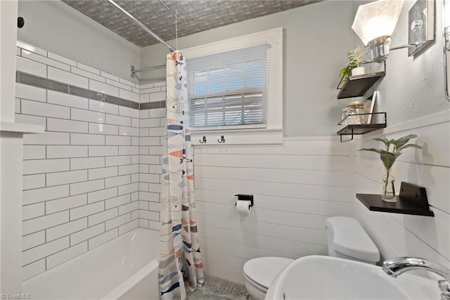 full bathroom featuring toilet, sink, and shower / tub combo with curtain