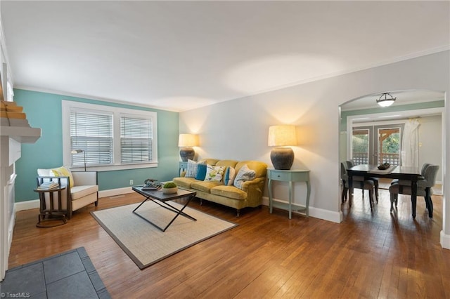 living room with wood-type flooring and ornamental molding