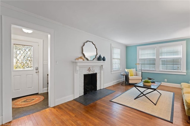 living room with hardwood / wood-style floors, a brick fireplace, a wealth of natural light, and crown molding