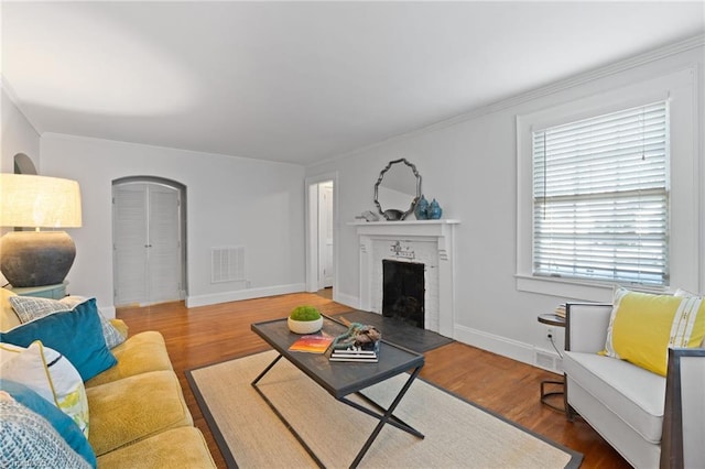 living room with hardwood / wood-style floors and a brick fireplace