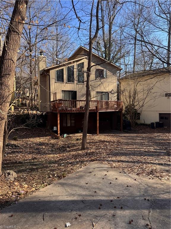 view of front of home with a chimney and a deck