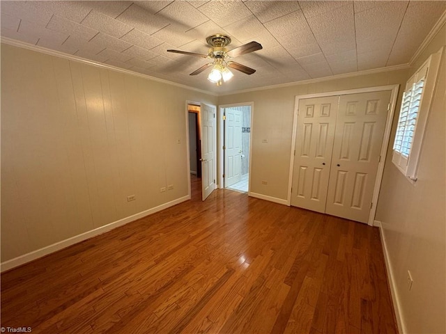 unfurnished bedroom with ornamental molding, hardwood / wood-style floors, and ceiling fan