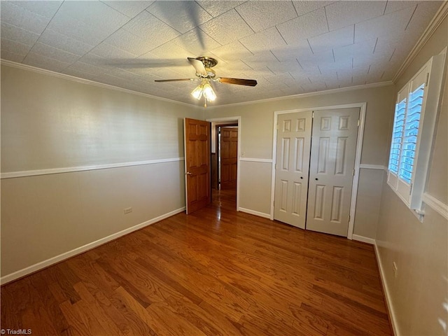 unfurnished bedroom featuring hardwood / wood-style floors, ornamental molding, and ceiling fan