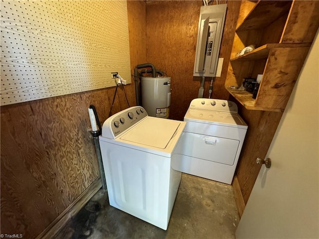 washroom featuring washer and dryer, electric panel, water heater, and wood walls