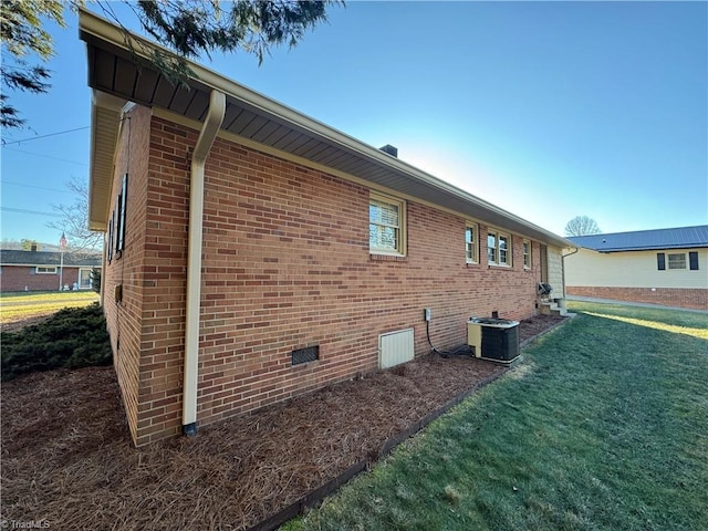 view of home's exterior with a yard and central AC