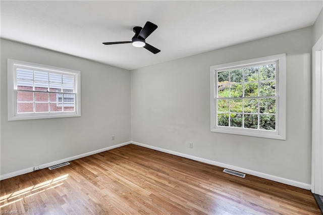 empty room with ceiling fan and light hardwood / wood-style floors