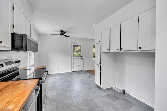 kitchen with white cabinets, ceiling fan, stainless steel stove, and wooden counters