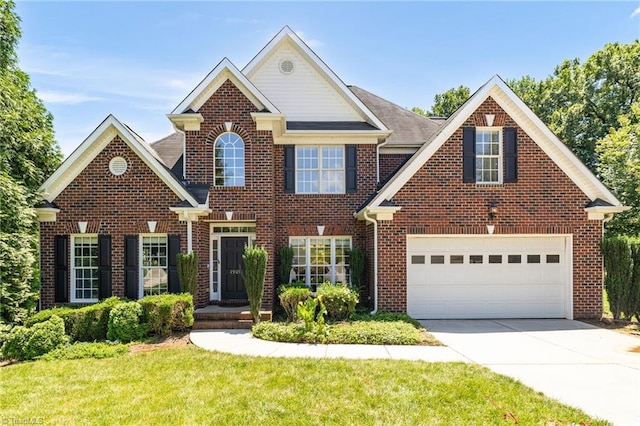 1905 Overshoot Ct, Greensboro, NC 27455 - view of front of property with concrete driveway, brick siding, and a front yard