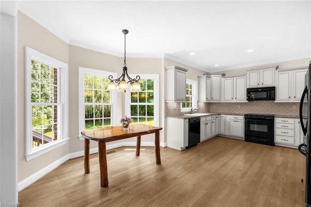 1905 Overshoot Ct, Greensboro, NC 27455 - kitchen with black appliances, crown molding, a chandelier, backsplash, and light wood-style flooring