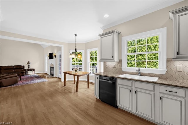 1905 Overshoot Ct, Greensboro, NC 27455 - kitchen with black dishwasher, tasteful backsplash, open floor plan, light wood-type flooring, and a glass covered fireplace