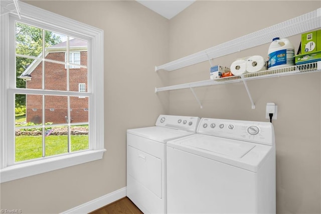 1905 Overshoot Ct, Greensboro, NC 27455 - washroom featuring washing machine and clothes dryer, healthy amount of natural light, and wood finished floors
