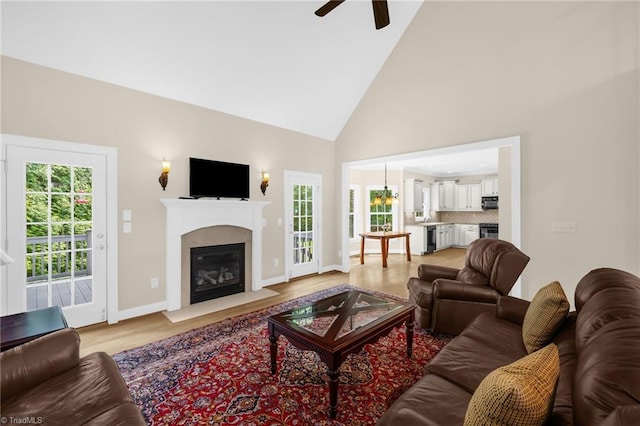 1905 Overshoot Ct, Greensboro, NC 27455 - living area with light wood-type flooring, a ceiling fan, a fireplace with flush hearth, and high vaulted ceiling
