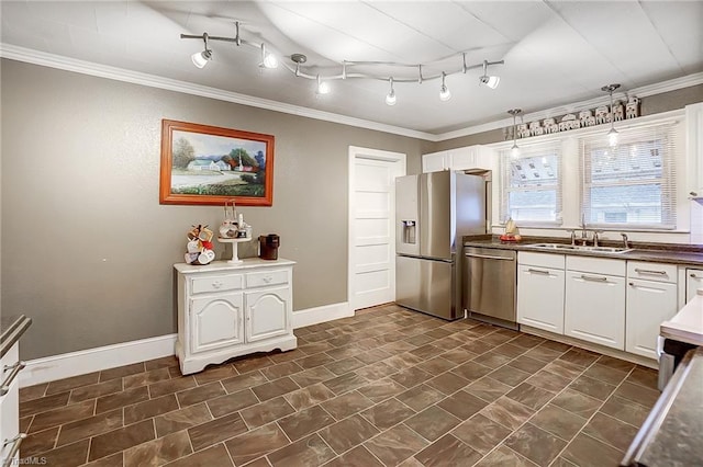 kitchen featuring appliances with stainless steel finishes, white cabinetry, crown molding, and sink