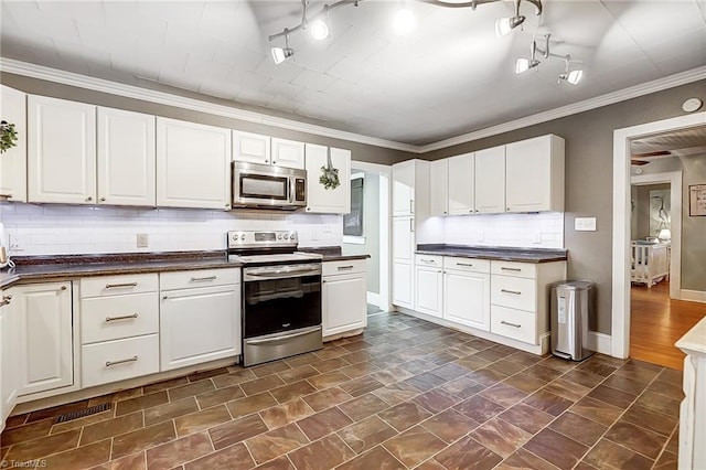 kitchen with white cabinetry, ornamental molding, appliances with stainless steel finishes, and tasteful backsplash