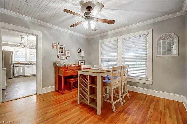 dining area featuring ceiling fan, light hardwood / wood-style flooring, crown molding, and sink