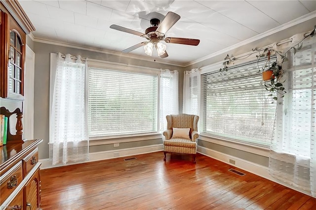 unfurnished room with crown molding, plenty of natural light, and hardwood / wood-style flooring