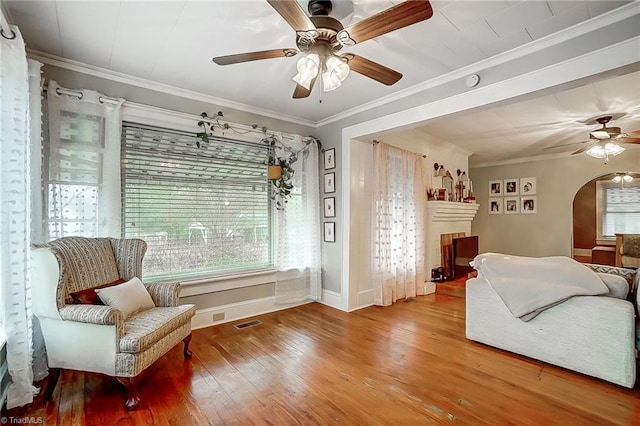 living area featuring crown molding, ceiling fan, and wood-type flooring