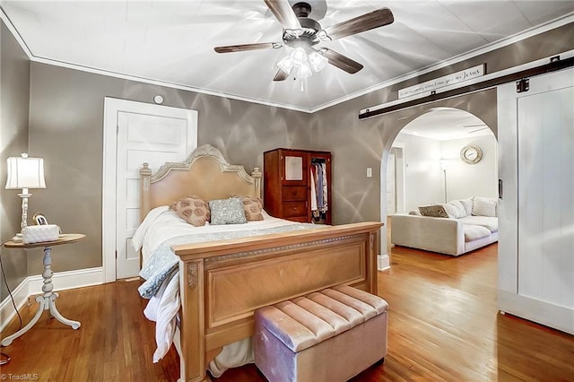 bedroom featuring wood-type flooring, ceiling fan, and crown molding