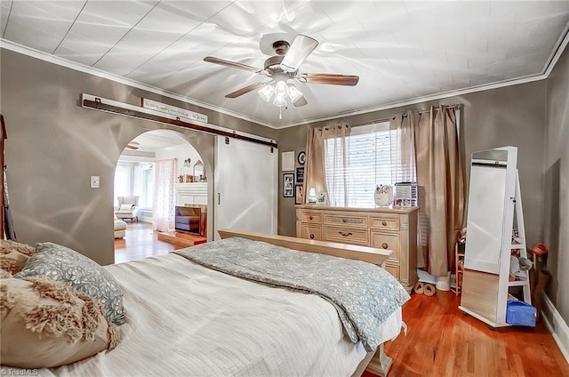 bedroom featuring light hardwood / wood-style flooring, ceiling fan, and ornamental molding