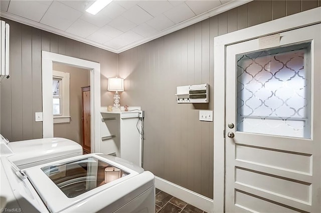 entryway featuring washer and dryer, wood walls, and crown molding