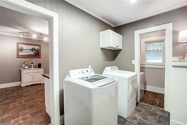 clothes washing area with separate washer and dryer, crown molding, and cabinets