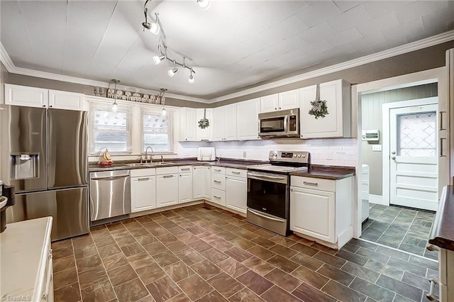 kitchen featuring appliances with stainless steel finishes, white cabinetry, ornamental molding, and sink