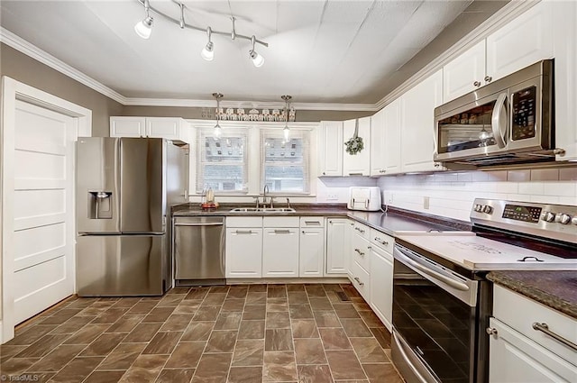 kitchen with ornamental molding, stainless steel appliances, sink, pendant lighting, and white cabinets