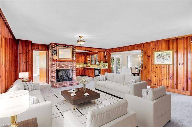 living area featuring light carpet, wood walls, and a fireplace