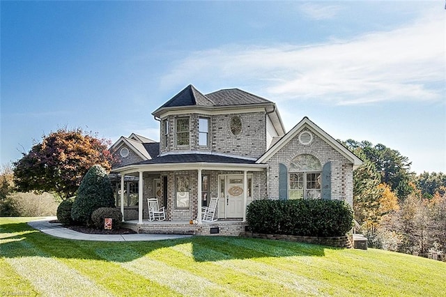 view of front of house with a front yard and a porch