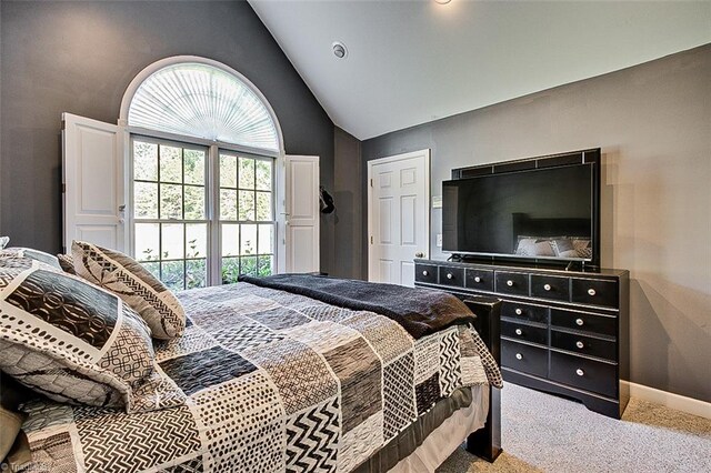 carpeted bedroom featuring high vaulted ceiling