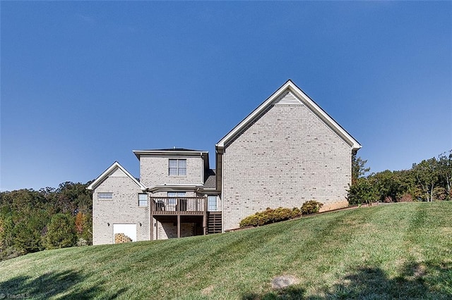 back of house featuring a wooden deck and a lawn