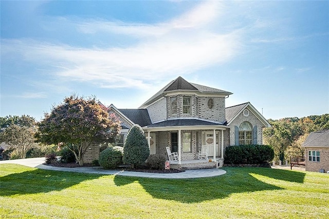 view of front of property with a porch and a front lawn