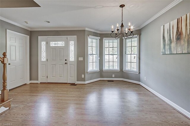 entryway with an inviting chandelier, light hardwood / wood-style flooring, and ornamental molding