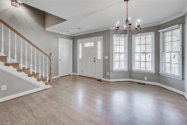 entrance foyer with light hardwood / wood-style floors, a notable chandelier, and ornamental molding