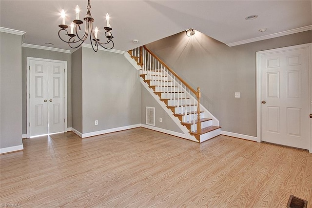 interior space with ornamental molding, a chandelier, and light wood-type flooring