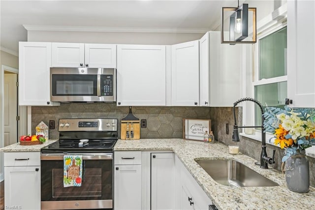 kitchen featuring appliances with stainless steel finishes, a sink, white cabinets, crown molding, and backsplash