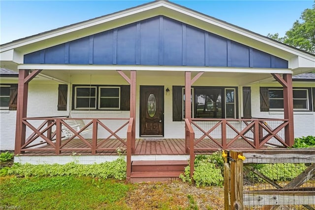 view of front of house featuring brick siding, board and batten siding, and a porch