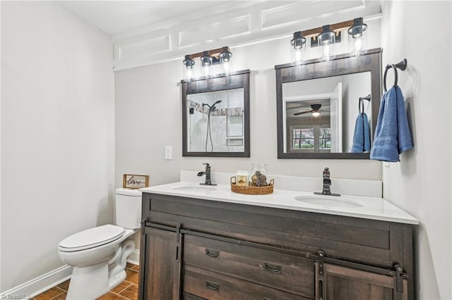 full bathroom with toilet, double vanity, a ceiling fan, and baseboards